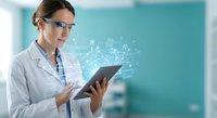 Female scientist in white lab coat using digital tablet with holographic data visualization in modern laboratory for medical research and technology.
