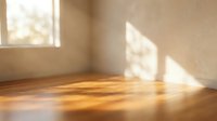 Empty room with warm sunlight streaming through windows onto polished wooden floor creating natural shadows and peaceful atmosphere for interior design.