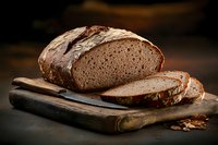 Fresh sliced artisanal sourdough bread loaf on rustic wooden cutting board with bread knife against dark moody background, food photography.