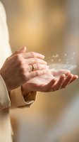 Cupped hands releasing glowing light particles with magical sparkles floating upward in warm golden atmosphere for spiritual and wellness concepts.