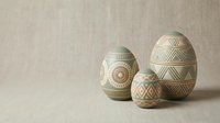 Decorative ceramic eggs with geometric patterns and tribal motifs arranged on neutral linen background for Easter crafts and spring home decor projects.