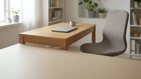 Modern minimalist home office workspace with wooden desk, gray ergonomic chair, laptop and coffee cup in bright natural light interior setting.