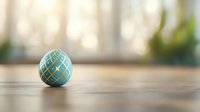 Decorative turquoise ceramic ball with gold geometric pattern on wooden surface against soft blurred background. Minimalist home decor composition.
