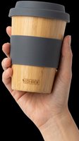 Reusable bamboo coffee cup with gray silicone grip band and lid, held in hand. Isolated on transparent background, ready for t-shirt design, clipart, stickers, and print-on-demand products.