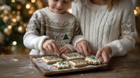 Mother and child decorating Christmas cookies together on wooden table with festive bokeh lights in background, creating holiday traditions.