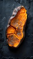 Baked sweet potato with scored skin glowing orange on dark textured background, overhead view. Perfect for food blogs and restaurant menus.