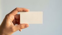 Hand holding blank business card mockup on neutral background for branding and corporate identity design projects.