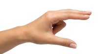 Woman's hand showing small size measurement gesture isolated on white background for design and commercial use.