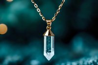 Gold chain necklace with crystal quartz pendant on teal bokeh background for jewelry fashion and accessories design.