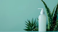 White cosmetic pump bottle with aloe vera plants against mint green background, minimalist spa composition for natural skincare and beauty products.