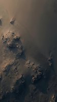 Aerial view of dramatic coastline with dark rocky formations and sandy beach creating natural patterns and textures from above.