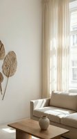 Minimalist living room with beige sofa, wooden table, dried leaf wall art, and sheer curtains filtering natural light through large window for home decor.