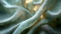 Ethereal flowing fabric in mint green and gold tones creates abstract waves and curves with soft textile texture and luminous light effects for luxury backgrounds.
