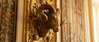 Ornate golden decorative molding with intricate carved details and classical architectural embellishments, suitable for luxury interior design, heritage restoration, and architectural reference materials.