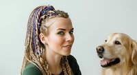 Young woman with braided hair and golden retriever dog together on white background, suitable for pet care, companionship, and lifestyle marketing materials.
