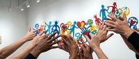 Multiple diverse hands reaching upward together toward colorful paper cutout figures representing people of various ages and abilities, symbolizing unity, teamwork, community support, and inclusive collaboration for nonprofit, charity, and social cause campaigns.