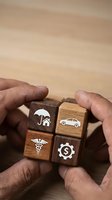 Hands protecting wooden blocks with insurance icons including home, car, health and financial coverage symbols for risk management and security planning.