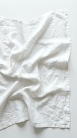 Crumpled white linen fabric with natural folds and wrinkles on neutral background, suitable for textile, fashion, and home decor design projects.