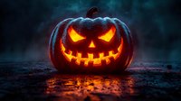 Glowing carved pumpkin with evil smile on dark misty background. Orange light illuminates spooky Halloween jack o lantern against dramatic foggy atmosphere.