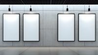 Four empty white vertical poster frames mounted on gray wall with overhead spotlights in modern gallery or retail space interior. Mock up for advertising display.