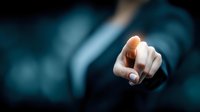 Close-up of businesswoman's hand pointing forward against dark blue background, conveying leadership and decision-making in corporate environment.