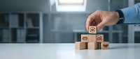 Businessman hand placing wooden cube with customer service icons on desk in modern office environment for business strategy and support concepts.