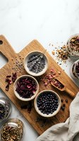 Assorted herbal teas and spices in wooden bowls on cutting board with glass jars, natural ingredients for healthy beverages and cooking recipes.