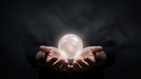 Hands holding glowing crystal ball against dark stormy sky, symbolizing fortune telling, divination, magic, and mystical prediction for spiritual guidance concepts.