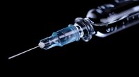 Medical syringe with needle on black background for healthcare and vaccination concepts in clinical settings and pharmaceutical applications.
