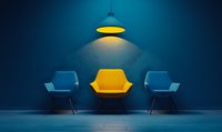 Modern waiting room interior with three designer armchairs in blue and yellow colors illuminated by hanging lamp against dark wall, minimalist office space.