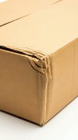 Damaged brown cardboard shipping box with torn edges and wear marks isolated on white background for delivery and packaging concepts.