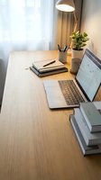 Modern home office workspace with laptop, notebooks and desk lamp on wooden table for remote work and productivity.