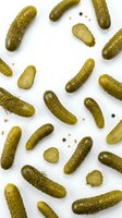 Whole and sliced dill pickles arranged on white background, isolated and ready for food packaging, recipe blogs, restaurant menus, culinary websites and grocery store marketing materials.