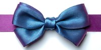 Elegant blue satin bow tie with purple ribbon band isolated on white background for formal wear accessories and fashion design projects.