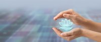 Caucasian female hands cradling a glowing holographic lotus flower symbol against a soft blurred digital grid background, wellness concept.
