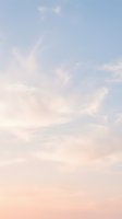 Soft pastel sky with fluffy white clouds in pink and blue hues creating dreamy atmosphere for backgrounds and peaceful nature scenes.
