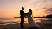 Silhouetted couple in wedding attire exchanging vows on sandy beach at sunset, golden sky and ocean waves behind them, romantic ceremony setting for weddings and celebrations.
