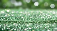 Sparkling green glitter background with soft bokeh effect and shimmering particles creating magical festive atmosphere for holiday designs and celebrations.