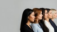 Diverse group of professional women in profile view showing multicultural team unity and collaboration in modern workplace setting.