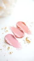 Pink lip gloss or cream smears with gold foil flakes on white background, luxury beauty product swatches for cosmetic branding.