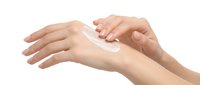 Woman applying moisturizing cream to hands for skincare routine, cosmetic product demonstration for beauty and wellness purposes.