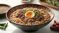 Spicy Asian ramen noodle soup with soft boiled egg, minced meat, and fresh herbs in dark ceramic bowl on white table with chili peppers.
