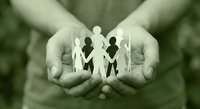 Protective hands holding paper cutout family figures symbolizing care, support, unity and social responsibility in community welfare concept.