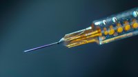 Close-up of medical syringe with amber liquid and thin needle against dark background, used in healthcare and pharmaceutical applications.