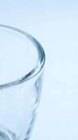 Clear glass rim close-up with soft blue tint on white background for kitchen, dining, beverage and tableware design concepts.