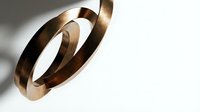 Modern copper metal rings with reflective surface casting dramatic shadows on white background for contemporary design projects.