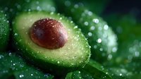 Fresh ripe avocado cut in half with water drops on dark green background with bokeh effect, macro food photography for healthy eating concept.