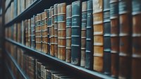 Row of vintage leather-bound books on wooden library shelf, showing aged spines in muted blue, brown and tan colors, creating atmospheric academic ambiance.