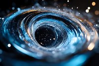 Swirling blue vortex with glowing particles and bokeh lights creates mesmerizing abstract pattern against dark background, capturing motion and energy in macro photography.