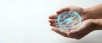 Hands holding transparent globe with colorful digital world map, representing global connectivity, international business, and worldwide communication networks.